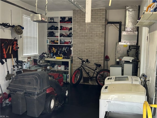 garage with a workshop area, a garage door opener, and separate washer and dryer