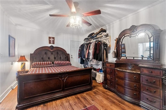 bedroom with ceiling fan, a closet, crown molding, and light hardwood / wood-style floors