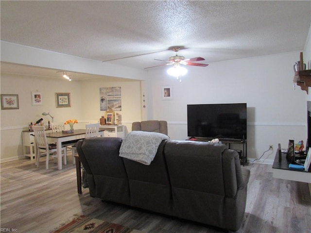 living room featuring a textured ceiling, ceiling fan, and hardwood / wood-style floors