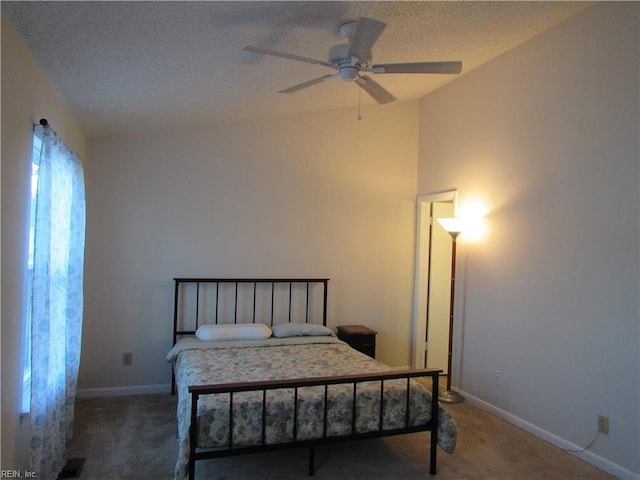 carpeted bedroom featuring ceiling fan and a textured ceiling