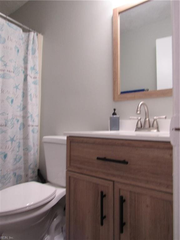 bathroom featuring toilet, vanity, and a shower with shower curtain