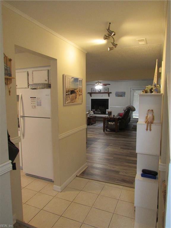 corridor featuring light tile patterned flooring and crown molding