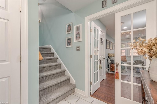 stairs with tile patterned floors and french doors