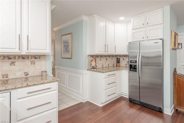 kitchen with stainless steel refrigerator with ice dispenser, dark hardwood / wood-style flooring, light stone counters, and white cabinets