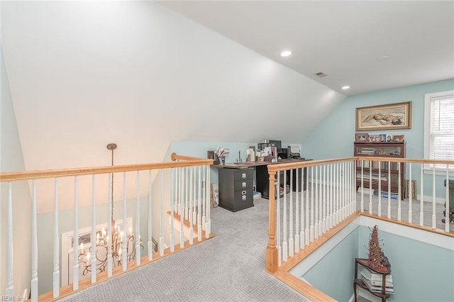 hallway featuring lofted ceiling and carpet flooring