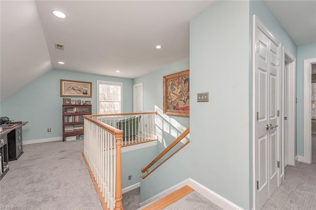 hall featuring vaulted ceiling and light colored carpet