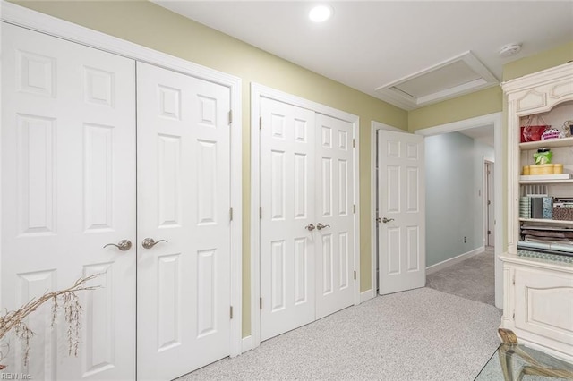 bedroom featuring two closets and light colored carpet