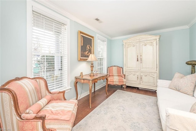 sitting room featuring ornamental molding and wood-type flooring