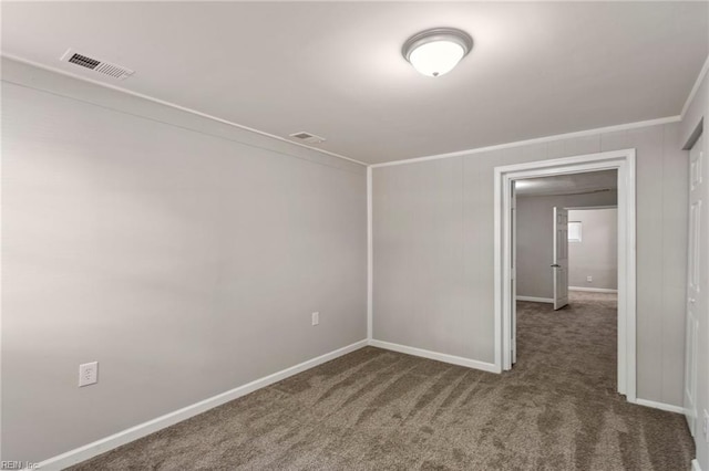 unfurnished room with dark colored carpet and crown molding