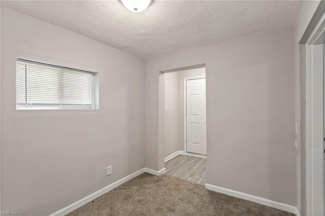 unfurnished room with light carpet and a textured ceiling