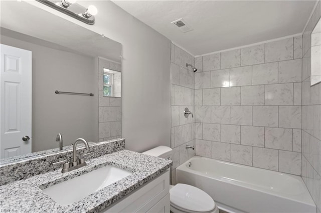 full bathroom featuring toilet, tiled shower / bath combo, and vanity