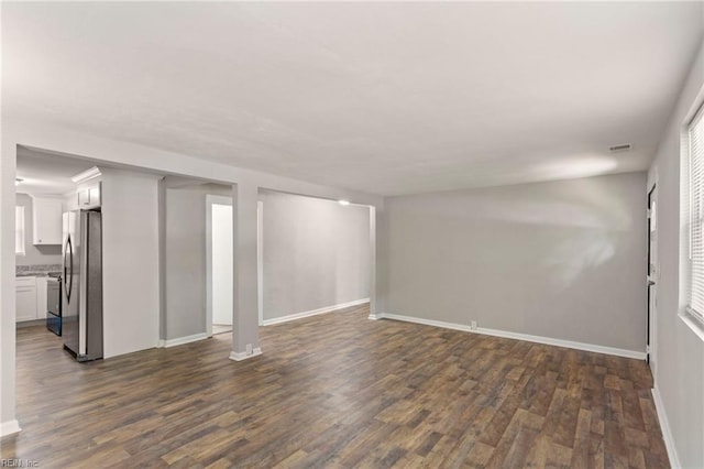 interior space with dark wood-type flooring and stainless steel fridge