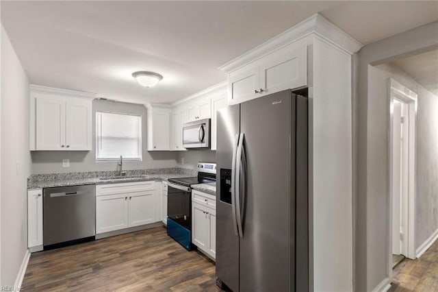 kitchen with sink, white cabinetry, light stone countertops, appliances with stainless steel finishes, and dark hardwood / wood-style flooring