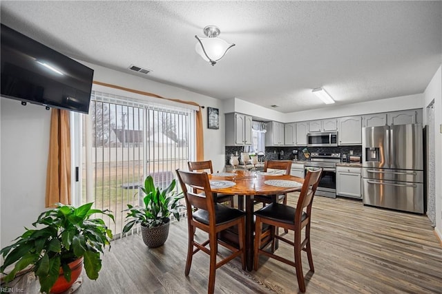 dining room featuring a textured ceiling and hardwood / wood-style floors