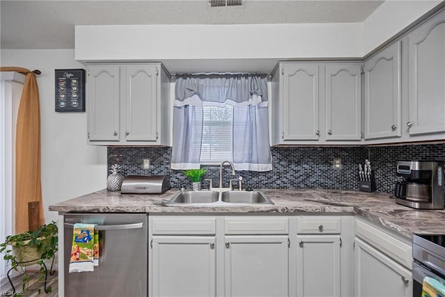 kitchen with stove, decorative backsplash, dishwasher, and sink