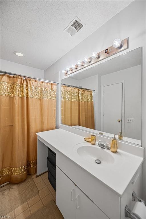 bathroom with vanity, tile patterned flooring, and a textured ceiling