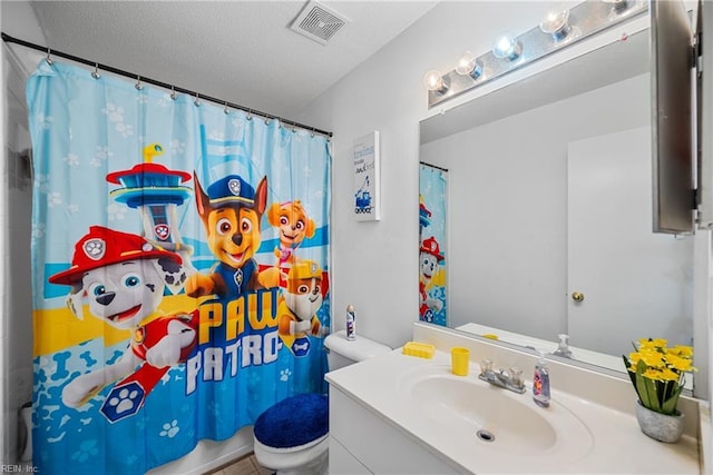 bathroom featuring toilet, vanity, and a textured ceiling