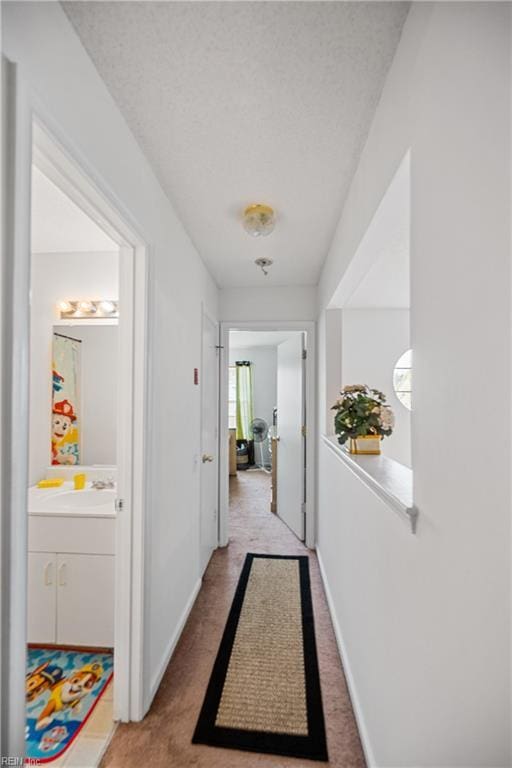 hallway featuring a textured ceiling and sink