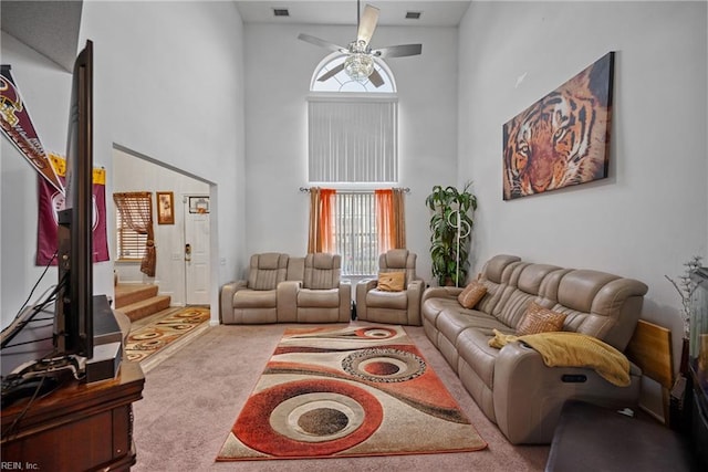 carpeted living room with high vaulted ceiling and ceiling fan