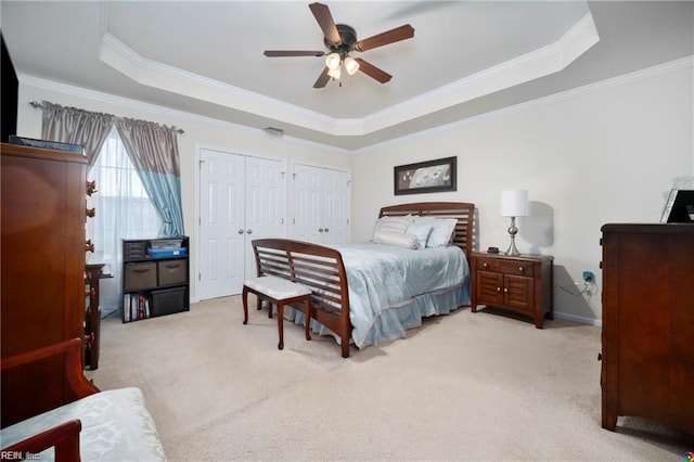 bedroom with light carpet and a raised ceiling