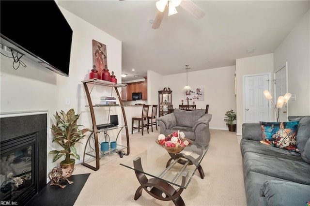 carpeted living room featuring ceiling fan