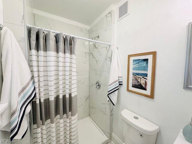 bathroom featuring a shower with curtain and toilet