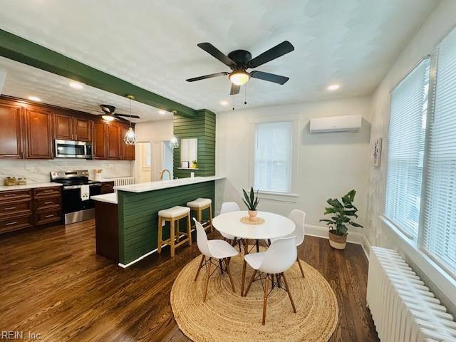 dining area featuring a wall mounted AC, dark hardwood / wood-style floors, radiator, and a healthy amount of sunlight