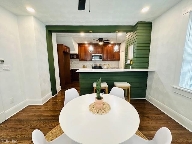 dining area featuring ceiling fan and dark hardwood / wood-style flooring