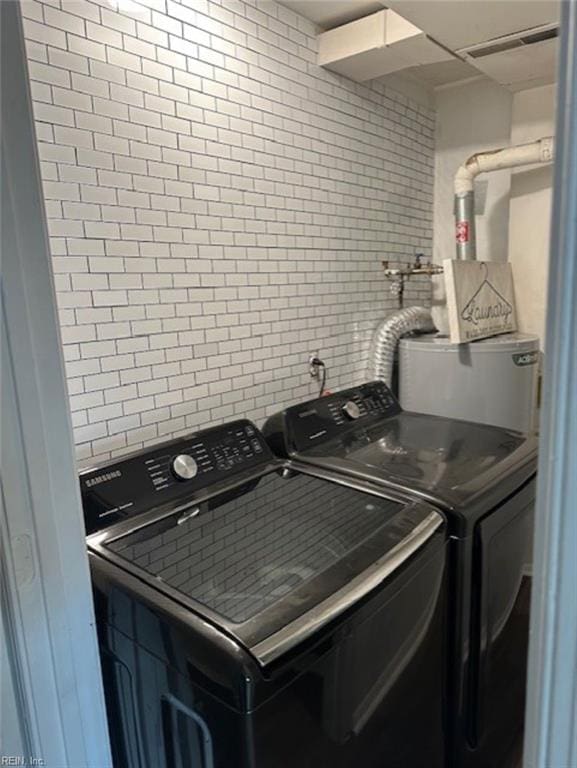 washroom featuring water heater and independent washer and dryer