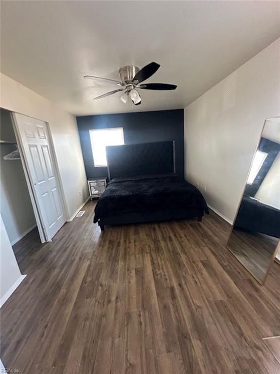 unfurnished bedroom with a closet, ceiling fan, and dark hardwood / wood-style flooring