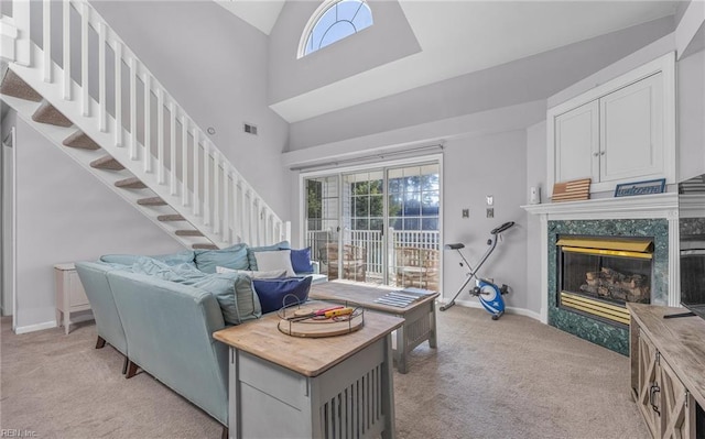 carpeted living room featuring high vaulted ceiling, a high end fireplace, and a wealth of natural light