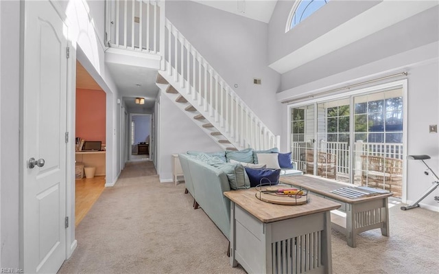 living room with light colored carpet and a towering ceiling