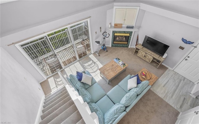 living room with light colored carpet and a high end fireplace