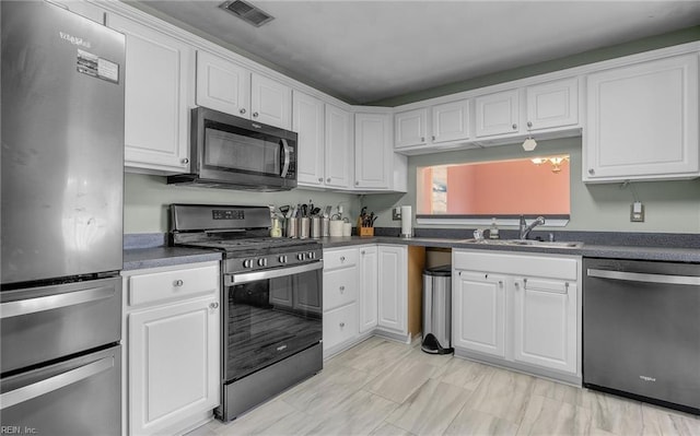 kitchen featuring stainless steel appliances, white cabinets, and sink