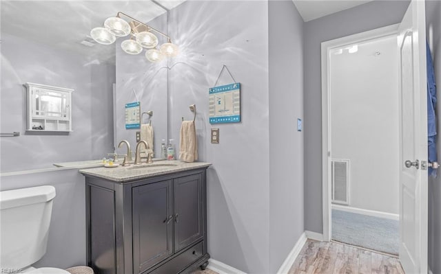 bathroom featuring hardwood / wood-style floors, toilet, and vanity