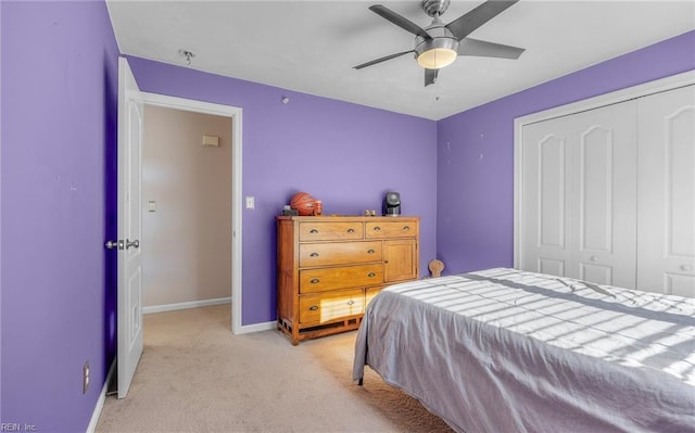 carpeted bedroom with ceiling fan and a closet