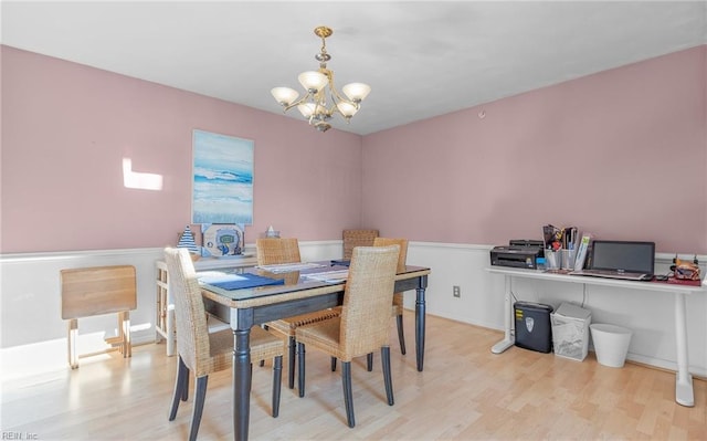 dining room with light wood-type flooring and a notable chandelier