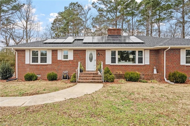 view of front of home with a front lawn and solar panels