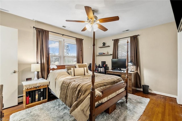 bedroom with ceiling fan, a baseboard radiator, and dark hardwood / wood-style floors