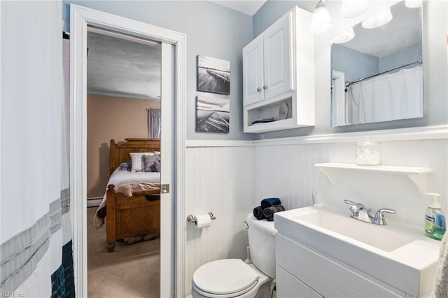 bathroom with vanity, toilet, and a baseboard heating unit