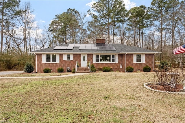 single story home featuring a front yard and solar panels