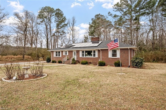 ranch-style home with a front yard and solar panels