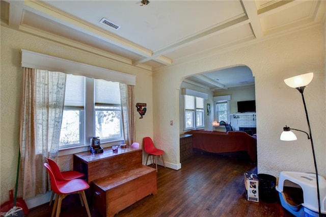 dining space featuring dark wood-type flooring, beamed ceiling, coffered ceiling, and a brick fireplace