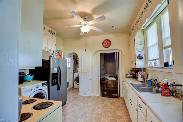 kitchen featuring white range with electric stovetop, white cabinetry, washer / clothes dryer, and sink