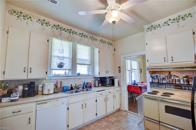 kitchen featuring sink, backsplash, white cabinets, and white appliances