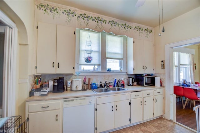 kitchen featuring tasteful backsplash, ceiling fan, dishwasher, sink, and white cabinetry