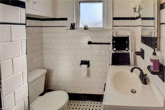 bathroom with sink, tile walls, toilet, and tile patterned flooring