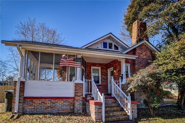 view of front facade featuring covered porch and a sunroom