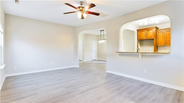 spare room featuring light hardwood / wood-style floors, sink, and ceiling fan