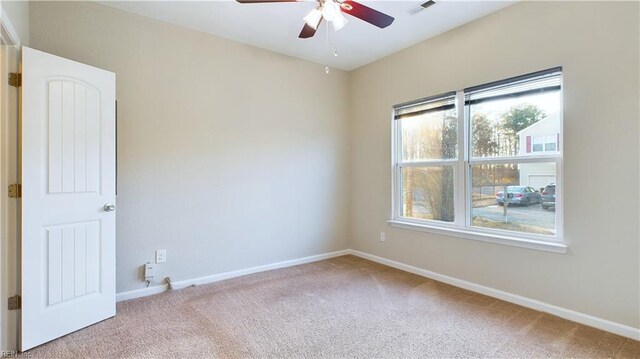 carpeted spare room featuring ceiling fan